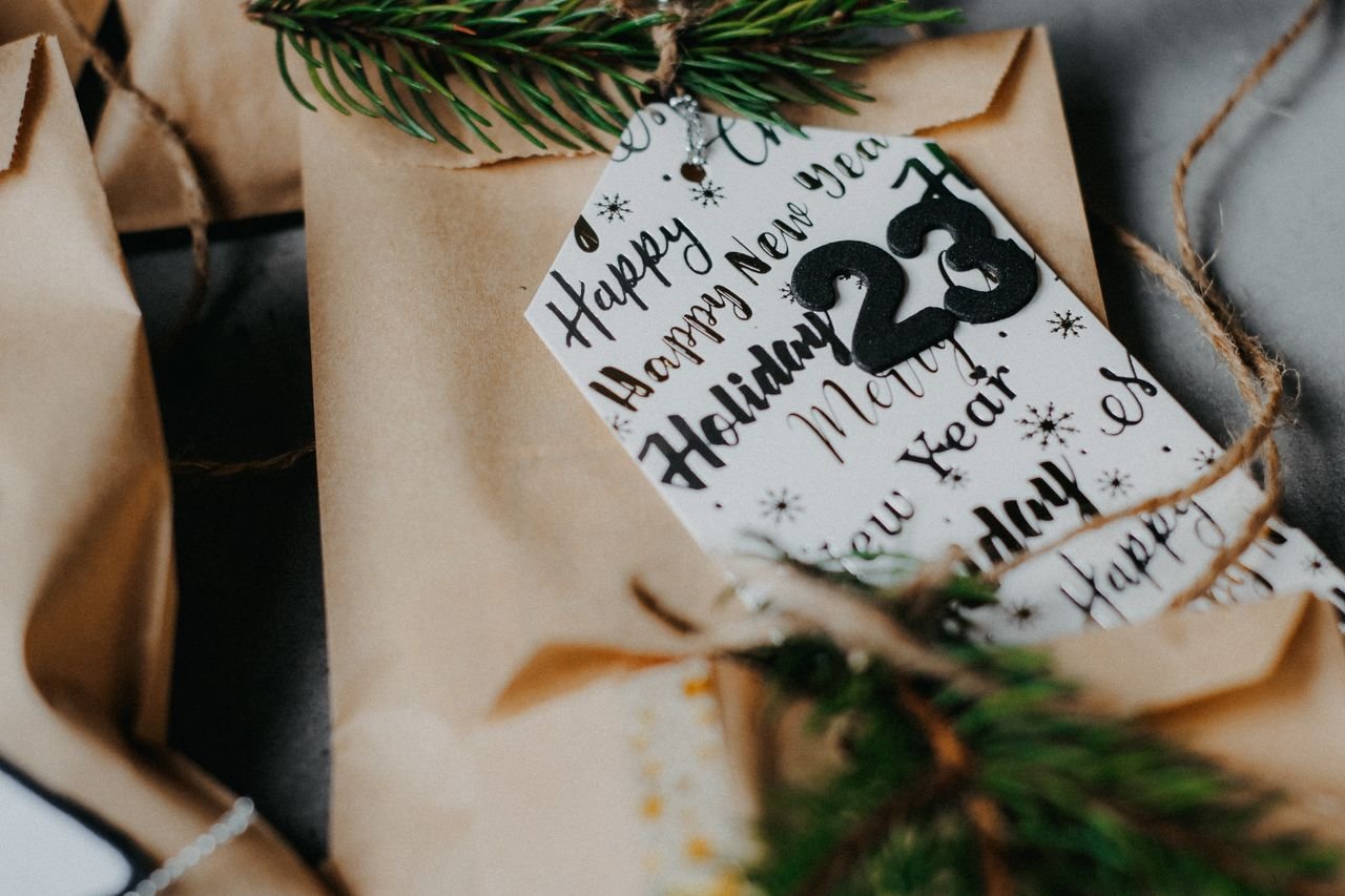 Home Close-up of festive packages with holiday-themed gift tags and pine decorations, perfect for 2023 Christmas gifting.