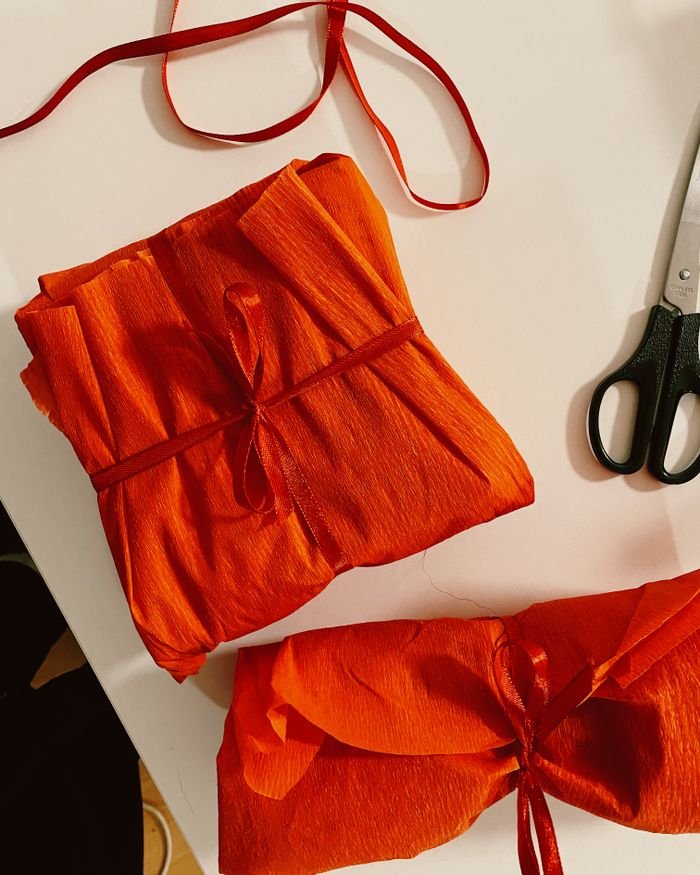 Beautifully wrapped gifts in red paper with ribbon, ready for gifting.