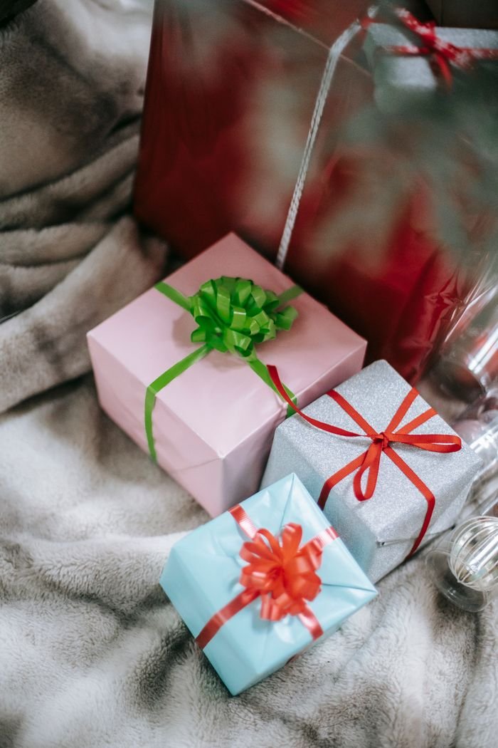 Home From above of wrapped gift boxes decorated with colorful ribbons placed on soft blanket