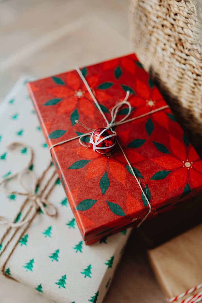 Close-up of beautifully wrapped Christmas presents with festive designs and twine ribbons.