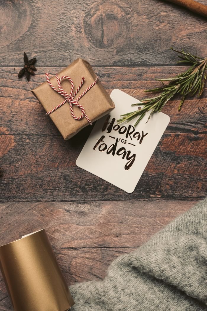 Home A charming gift box with a festive card on a rustic wooden table, perfect for holiday celebrations.